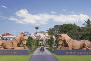 a car driving down a road in front of a building at JW Marriott Phu Quoc Emerald Bay Resort & Spa in Phu Quoc