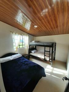 a bedroom with a bed and a wooden ceiling at CASA TURISTICA SAN JUAN DE OTTI in Monguí
