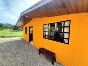 an orange building with a bench in front of it at CASA TURISTICA SAN JUAN DE OTTI in Monguí
