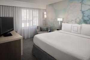 a hotel room with a large bed and a television at Courtyard Houston Westchase in Houston