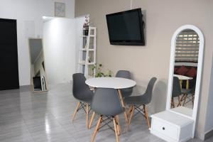 uma sala de jantar com mesa e cadeiras e uma televisão em Como en casa 2 em La Dorada