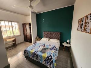 - une chambre avec un lit et un mur vert dans l'établissement Como en casa 2, à La Dorada