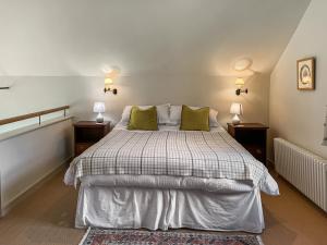 a bedroom with a large bed with two lamps at The Chapel in Owslebury