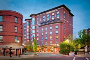 a large red brick building with a hotel at Courtyard by Marriott Boston Brookline in Brookline
