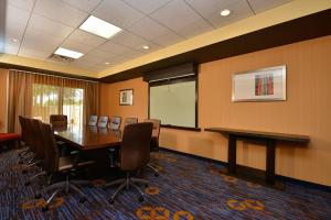 a conference room with a table and chairs and a whiteboard at Courtyard by Marriott Bentonville in Bentonville