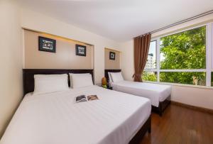 Habitación de hotel con 2 camas y ventana en Centre Point Hanoi Hotel, en Hanói