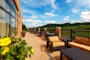 a patio with chairs and tables on a balcony at Courtyard Pittsburgh Settlers Ridge/Robinson Township in Robinson Township