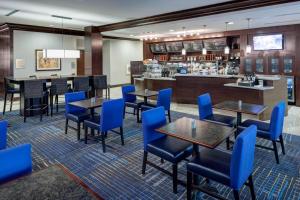 a restaurant with blue chairs and tables and a counter at Courtyard by Marriott Dallas Plano/Richardson in Plano