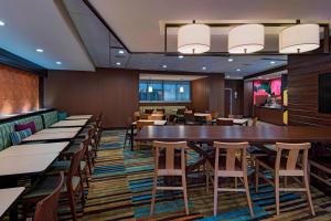 Fairfield Inn & Suites by Marriott Austin Buda في بودا: مطعم بطاولة وكراسي طويلة