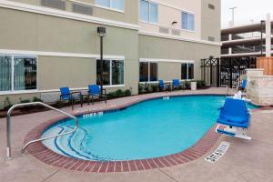 a swimming pool with blue chairs and a building at Courtyard by Marriott Dallas Plano/Richardson in Plano