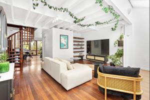 a living room with a white couch and chairs at 5 North Freo 2br Supercool Pad & Parking in North Fremantle