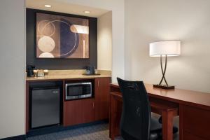 a hotel room with a desk with a microwave and a lamp at Courtyard Philadelphia Valley Forge / King of Prussia in Wayne