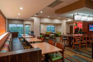 Fairfield Inn & Suites by Marriott Batesville في بيتسفيل: غرفة طعام مع طاولات وكراسي خشبية