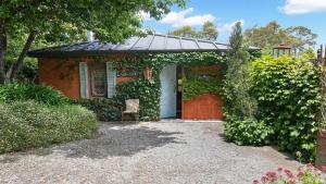 a small house with a door and a chair at Saint Eloi Le Studio in Bowral