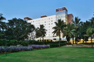 a hotel with a park in front of a building at Fairfield by Marriott Belagavi in Belgaum