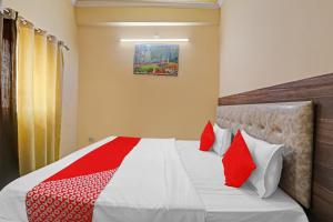 a bedroom with a bed with red and white pillows at OYO Flagship Hotel Four Square in Lucknow