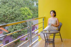 a woman sitting on a chair on a balcony at J and Ariya in Bophut 