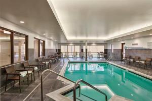 a pool in a hotel with chairs and tables at Courtyard Philadelphia/Langhorne in Langhorne
