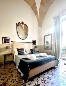 1 dormitorio con 1 cama grande y espejo grande en Eccelsoleccese, en Lecce