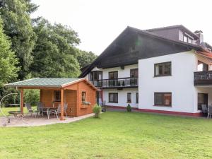 a large white house with a patio and yard at Quaint Apartment in Hüttenthal with Garden in Mossautal