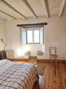 a bedroom with a bed and a chair and a window at THE OLIVE PRESS - Alentejo in Castelo de Vide