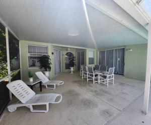 weranda z krzesłami, stołem i krzesłami w obiekcie Charming Vacation House 3Be 2Ba Solar heated pool w mieście Tampa