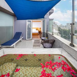 a balcony with a pool and red flowers at Harmony Saigon Hotel & Spa in Ho Chi Minh City