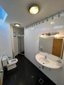a bathroom with a sink and a toilet and a mirror at Casa en bonito barrio residencial - Ciudad in El Challao