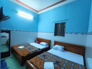 two beds in a room with blue walls at Ngoc Mai 2 Hotel in Can Tho