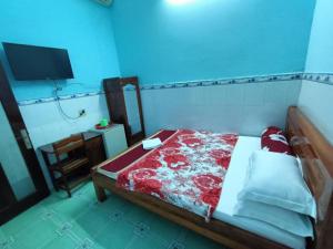 a bedroom with a bed with a red and white blanket at Ngoc Mai 2 Hotel in Can Tho