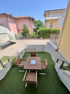 a patio with a table and benches on the grass at Appartamento Cipria in Sirmione