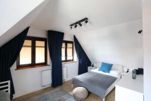 Schlafzimmer mit einem Bett mit blauen Kissen und Fenstern in der Unterkunft Nowodworski in Nowy Dwór Gdański