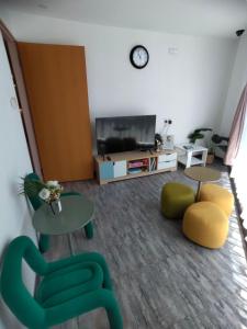 Sala de estar con 2 mesas y sillas y TV en Signel Hostel, en Kota Kinabalu