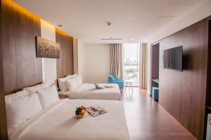 a hotel room with a bed and a couch at Gold Hotel Da Nang by Haviland in Da Nang