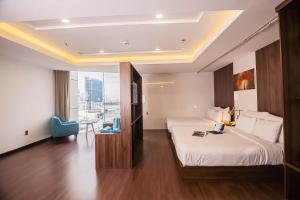 a hotel room with two beds and a table at Gold Hotel Da Nang by Haviland in Da Nang