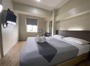 a bedroom with a large bed and a television at DG Budget Hotel Salem in Manila