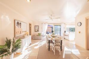 una sala da pranzo con tavolo e una sala da pranzo di White Sands, 14 Whitesands Road - Pet Friendly & Air Con a Fingal Bay