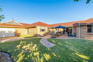 a backyard with a brick house with a patio at White Sands, 14 Whitesands Road - Pet Friendly & Air Con in Fingal Bay