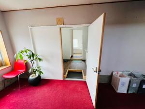 a room with a red carpet and an open door at HOSTEL OE in Yoshinogawa