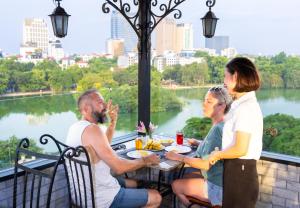 a group of people sitting around a table eating food at Centre Point Hanoi Hotel in Hanoi