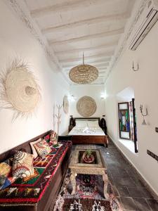 uma sala de estar com um sofá e uma cama em Riad Musa em Marraquexe