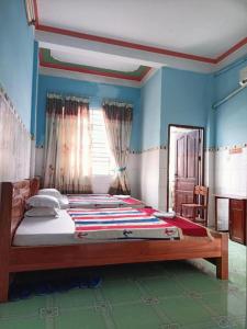 a bedroom with a large bed with blue walls at Ngoc Mai 2 Hotel in Can Tho