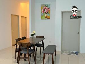 a dining room with a table and chairs and a door at Staycation Homestay 5 Hills 68 Apt Near Imperial in Kuching
