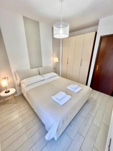 1 dormitorio con 1 cama grande y toallas. en Appartamento Cipria, en Sirmione