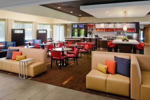 um restaurante com cadeiras e mesas e um bar em Courtyard by Marriott Huntsville University Drive em Huntsville