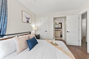 a bedroom with a large white bed with blue pillows at LOVELY Ocean View Beach House 3BR Sleeps 9 in San Diego