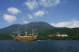Odakyu Hotel de Yama في هاكوني: قارب على الماء مع جبل في الخلفية
