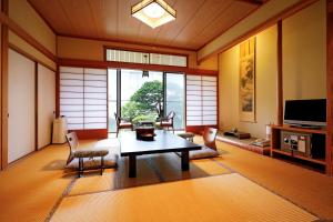 uma sala de estar com mesa e cadeiras em Tsubakikan em Aomori