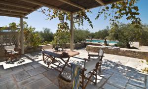 um pátio com uma mesa e cadeiras e uma piscina em Salvia em Kardamili
