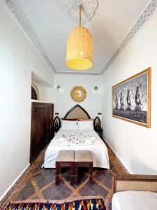 sypialnia z łóżkiem i żyrandolem w obiekcie Riad Musa w Marakeszu